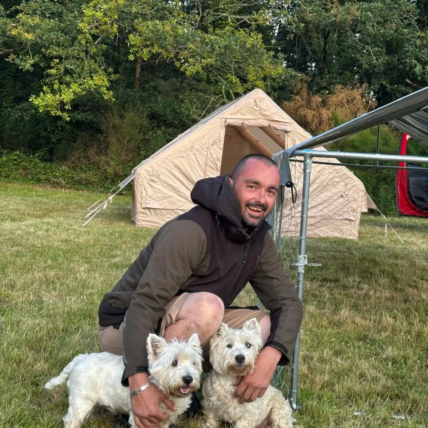 David Lenormand avec deux chiens devant l'installation mobile de la pension canine itinérante